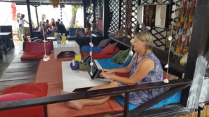 Sarah working in Thailand, sitting in a cafe at The Treehouse on Silent Beach