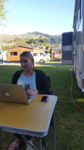 Sarah sat at a camping table working on her laptop